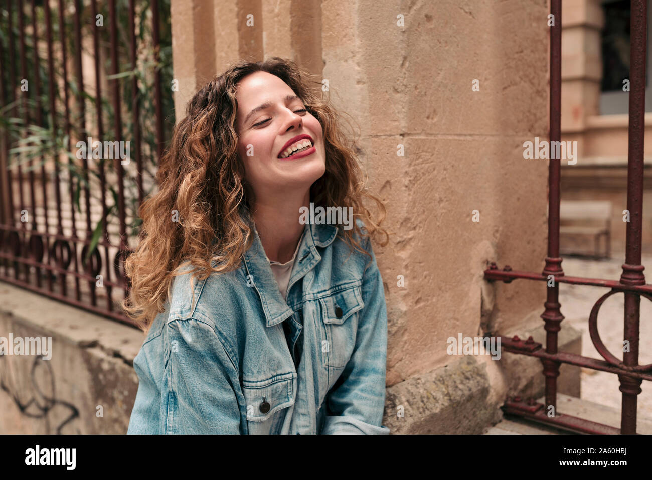 Jeune femme avec des cheveux bouclés et lunettes dans la ville Banque D'Images