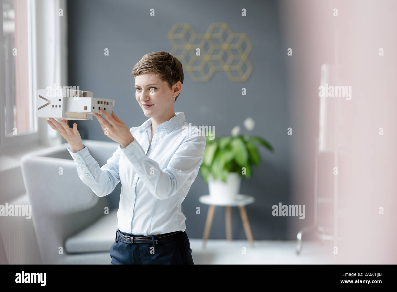 Confident businesswoman holding architectural model in office Banque D'Images
