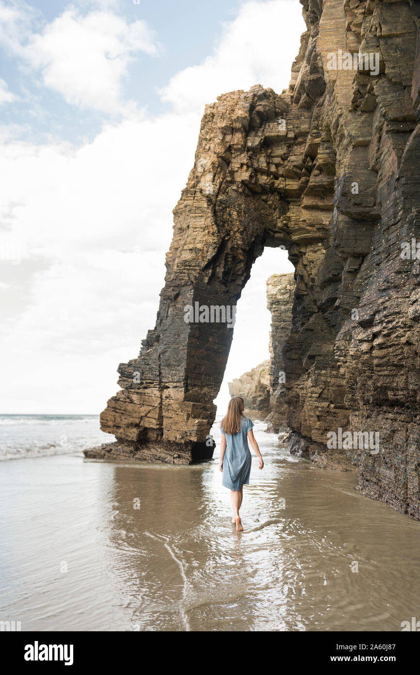 Femme marche sur la plage des Cathédrales de pierres, vue arrière, Galice, Espagne Banque D'Images