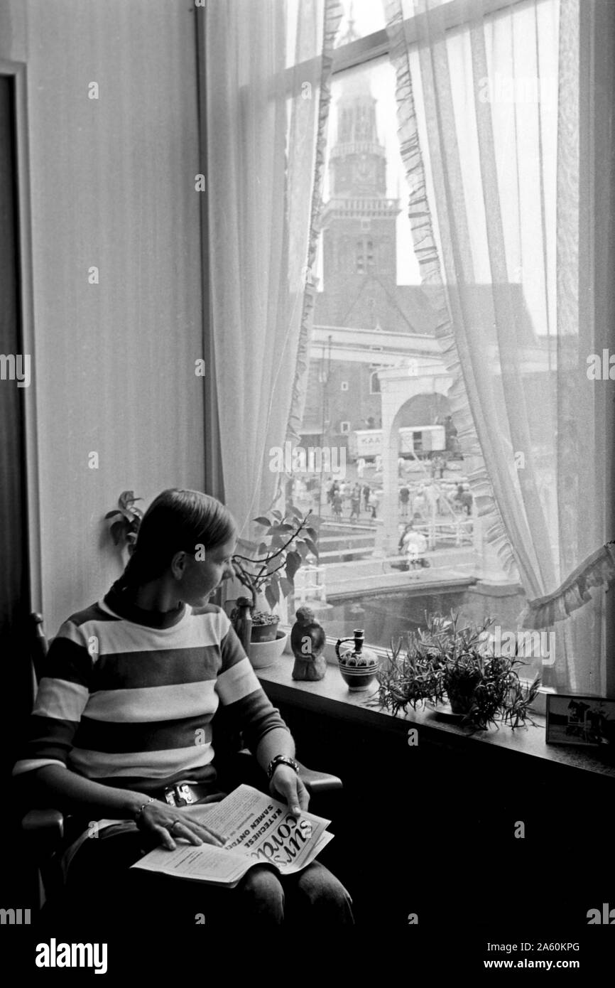 Eine junge Holländerin guckt aus dem Fenster, Alkmaar Pays-bas 1971. Une jeune femme néerlandaise en regardant par la fenêtre,Alkmaar Pays-bas 1971. Banque D'Images