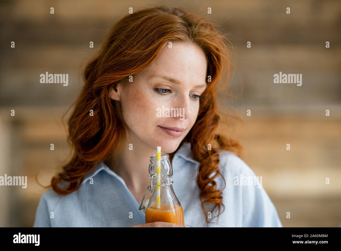 Portrait de femme rousse de boire du jus Banque D'Images