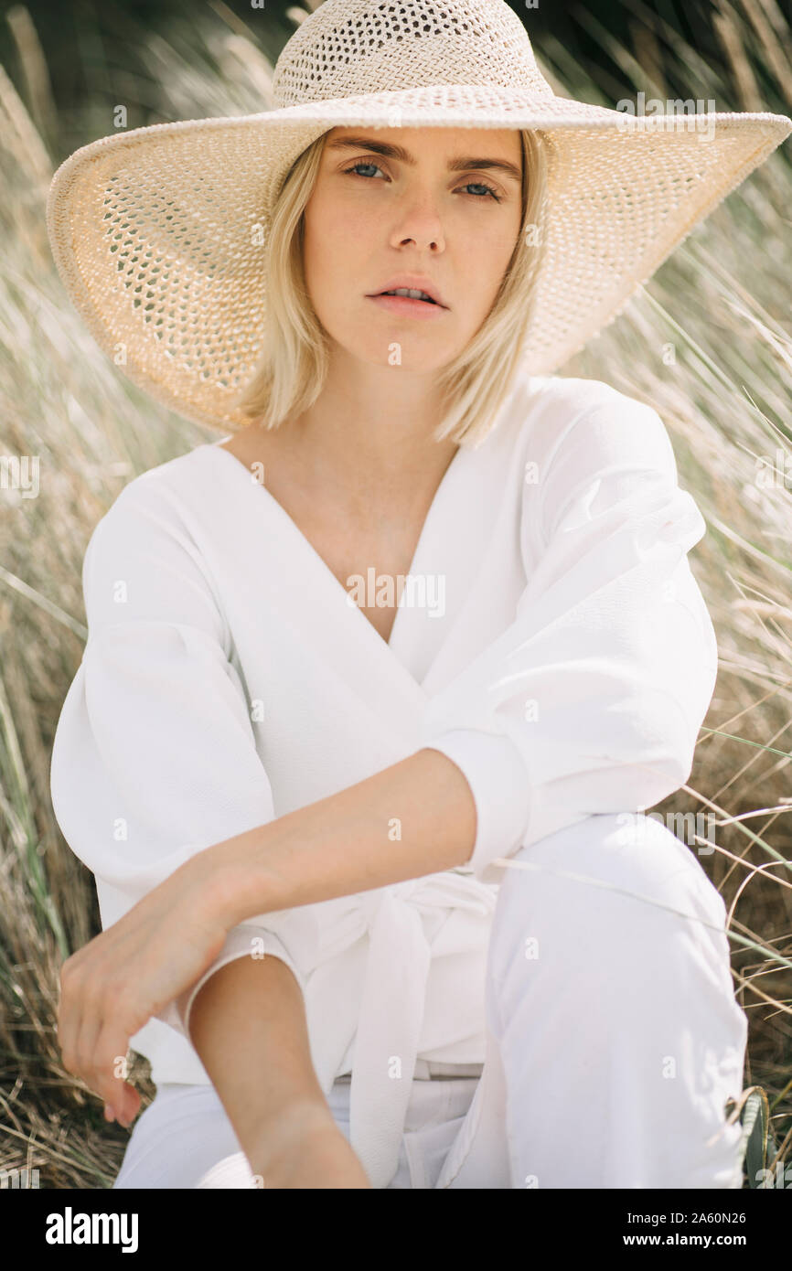 Portrait de jeune femme blonde en blouse blanche portant des dunes wrap et été hat Banque D'Images
