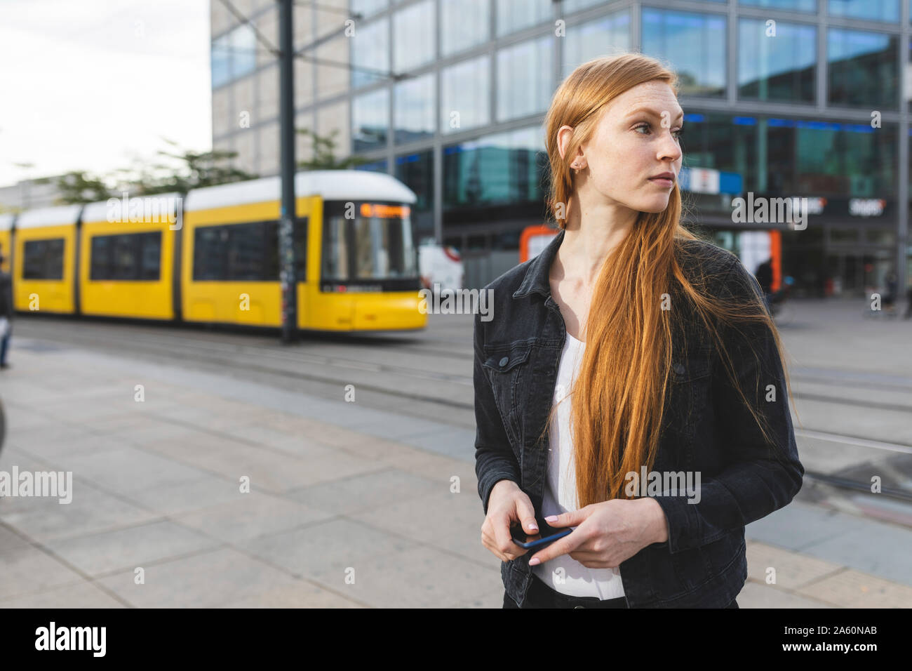 Jeune femme rousse en attente à Alexanderplatz, Berlin, Allemagne Banque D'Images