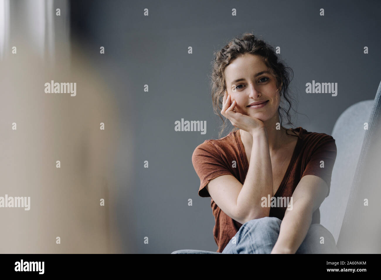 Portrait of smiling young woman relaxing at home Banque D'Images