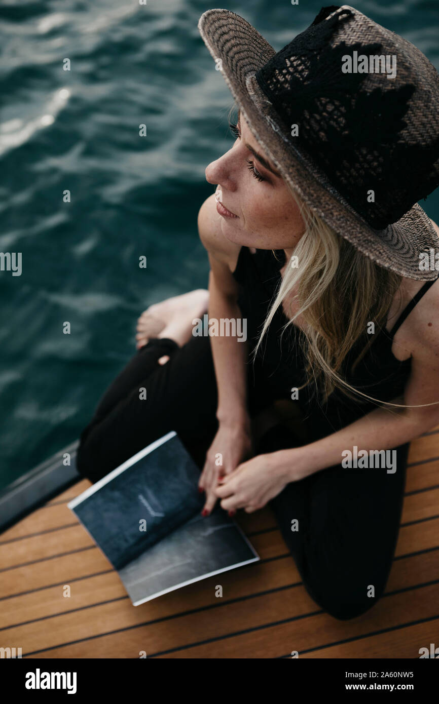 Femme avec un livre sur un bateau Banque D'Images
