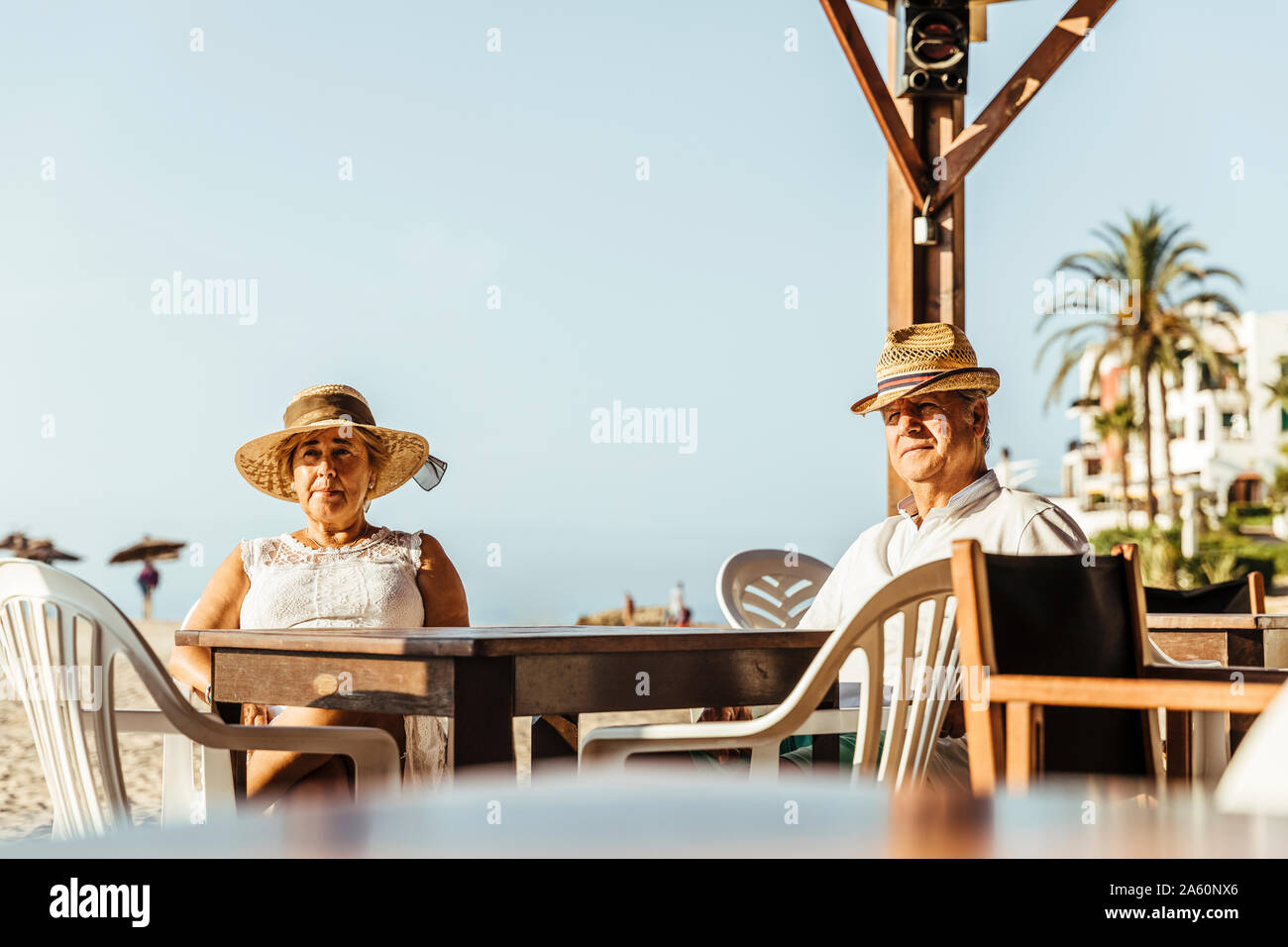 Senior couple sitting at a bar terrasse sur la plage, El Roc de Sant Gaieta, Espagne Banque D'Images