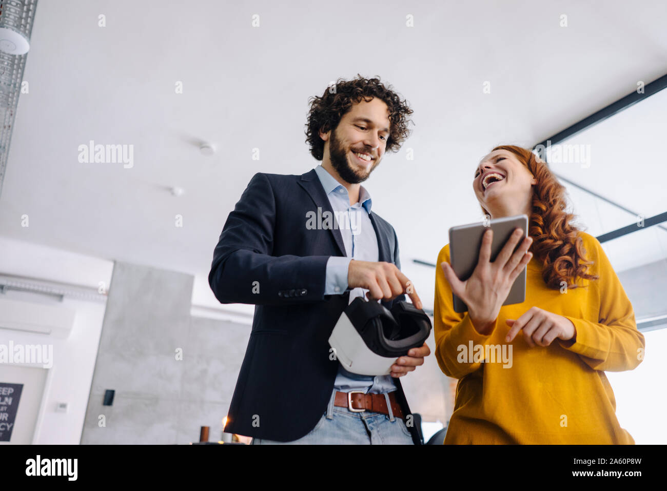 Happy businessman and businesswoman avec lunettes VR et tablet in office Banque D'Images