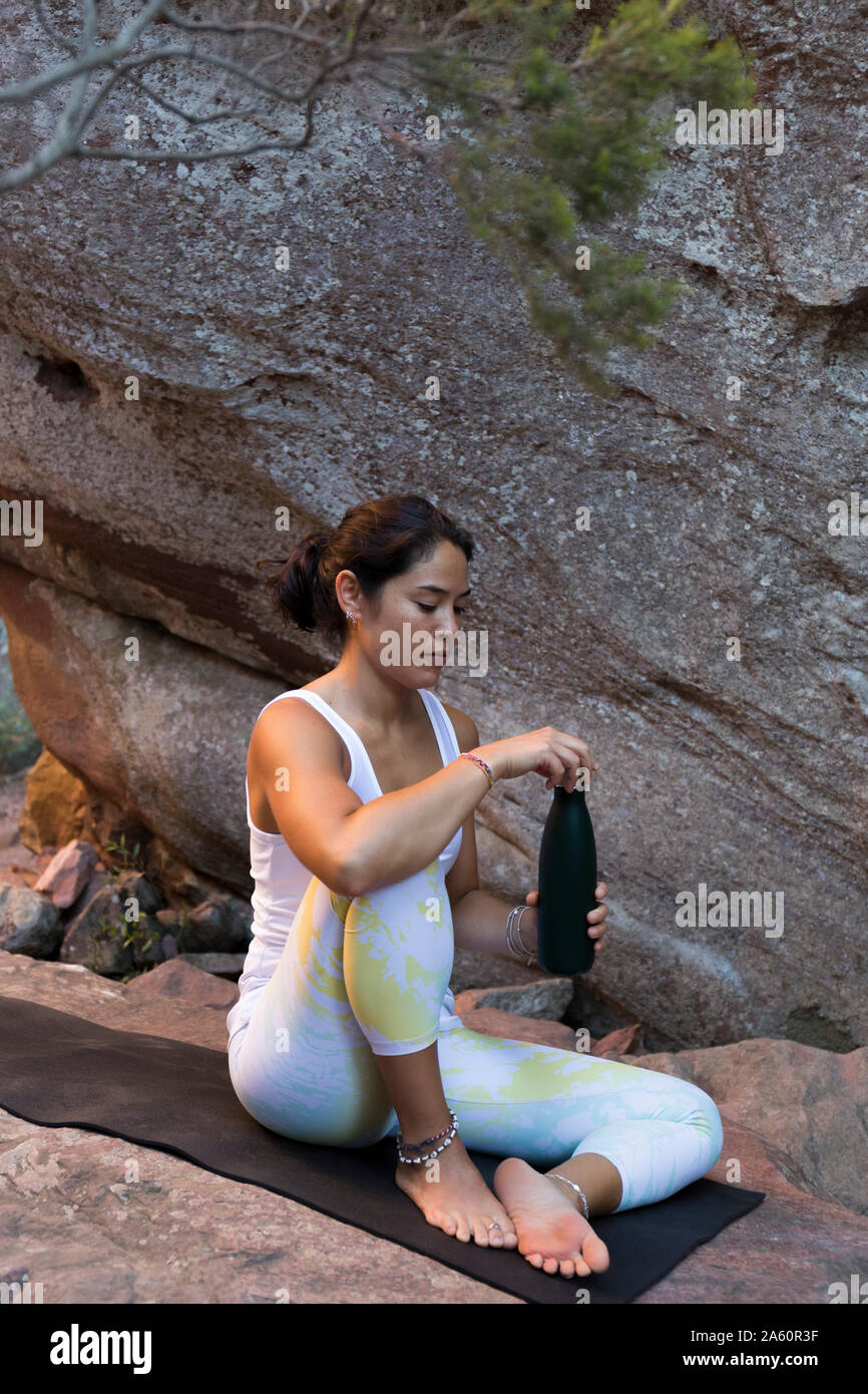 Young Asian woman boire d'une bouteille au cours de yoga Banque D'Images