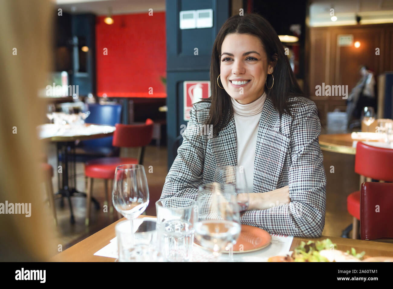 Portrait of smiling businesswoman sitting at table in restaurant Banque D'Images