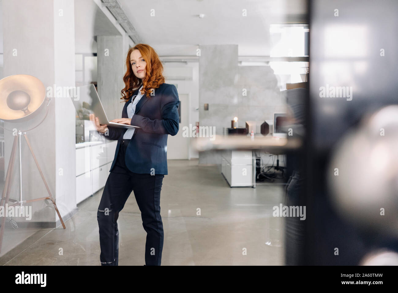 Portrait de redheaded businesswoman using laptop in office Banque D'Images