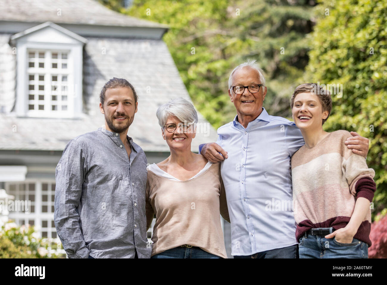 Happy senior couple avec enfants adultes debout dans leur maison de jardin Banque D'Images