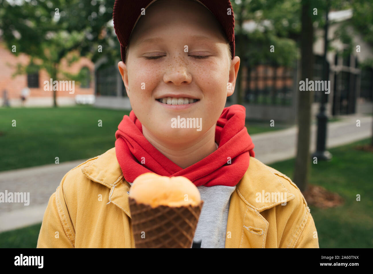 Garçon aux yeux clos, holding ice cream Banque D'Images