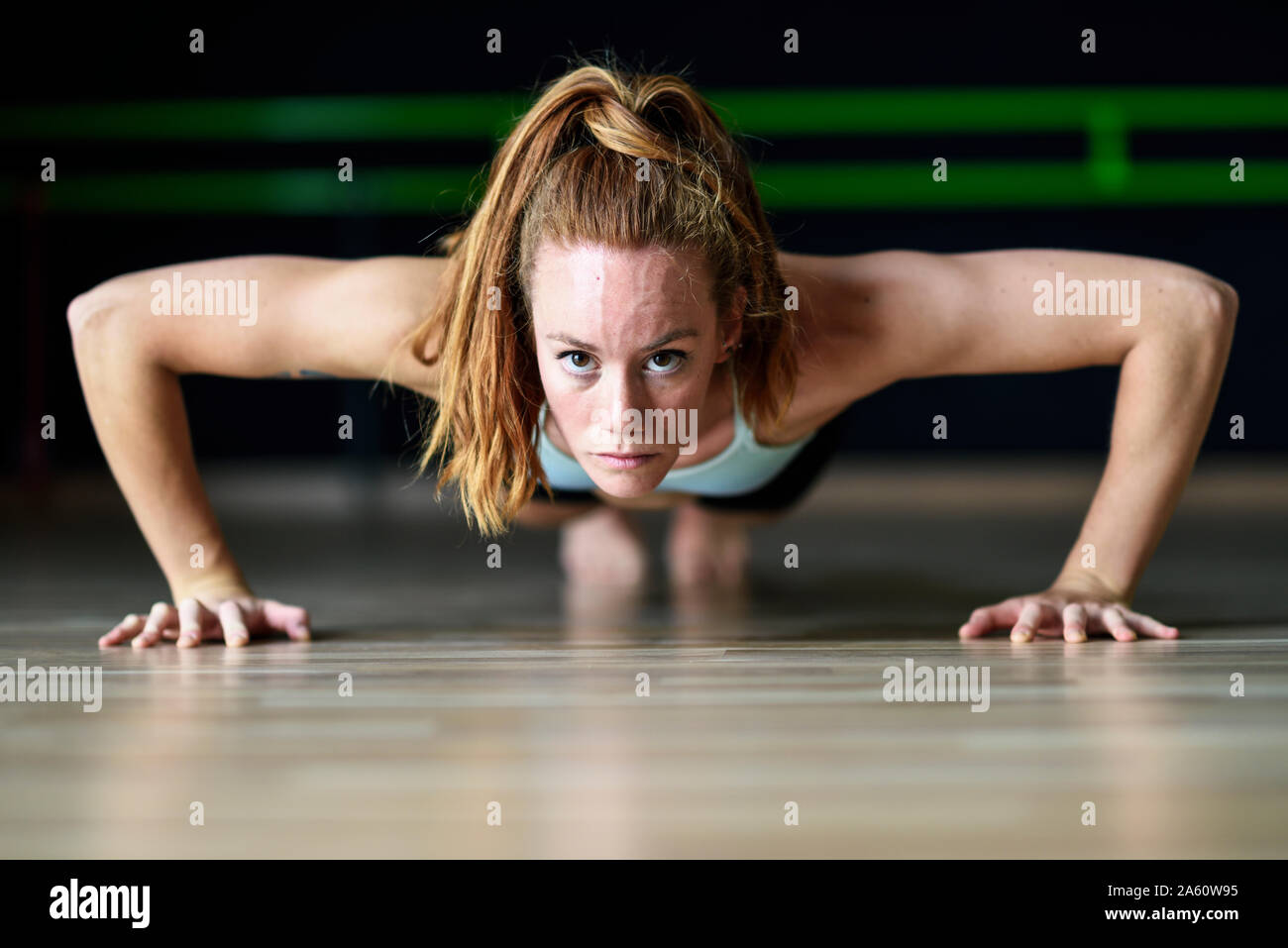 Sporty young woman doing push-ups dans une salle d'exercice Banque D'Images