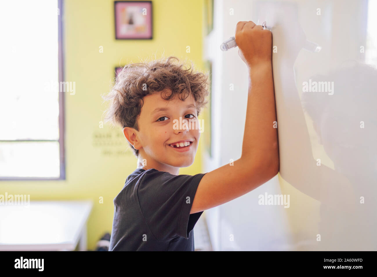 Portrait of smiling boy s'appuyant sur un tableau. Banque D'Images