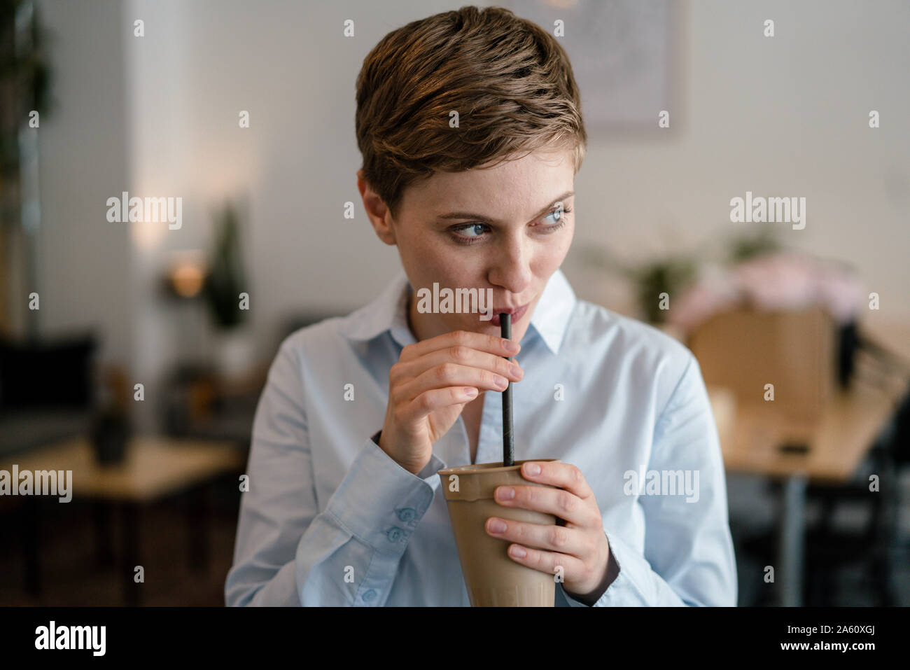 Businesswoman in a cafe mug de potable Banque D'Images