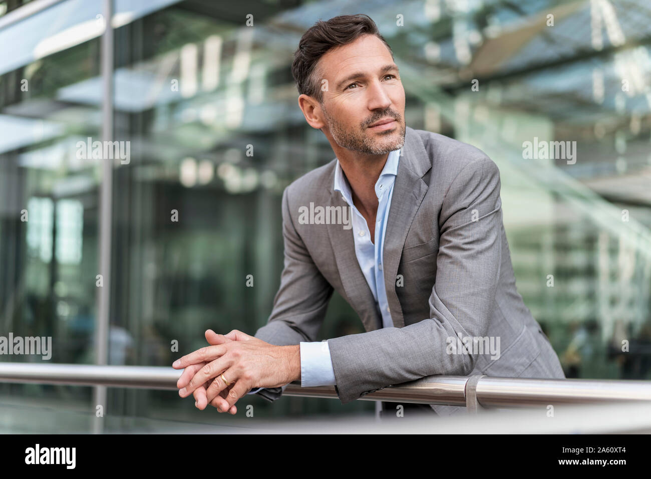 Businessman dans la ville leaning on railing Banque D'Images