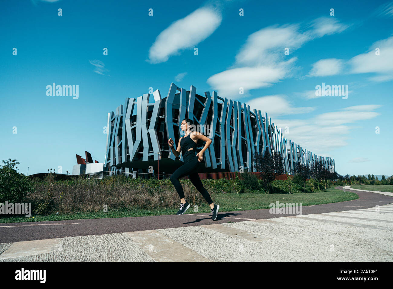 Jeune femme sur un chemin de jogging, un bâtiment moderne dans l'arrière-plan Banque D'Images