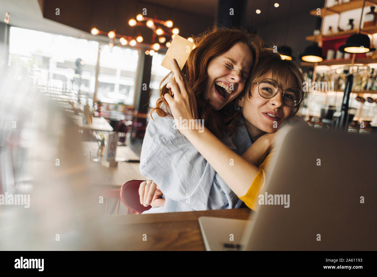Deux excités female friends with laptop and credit card in a cafe Banque D'Images