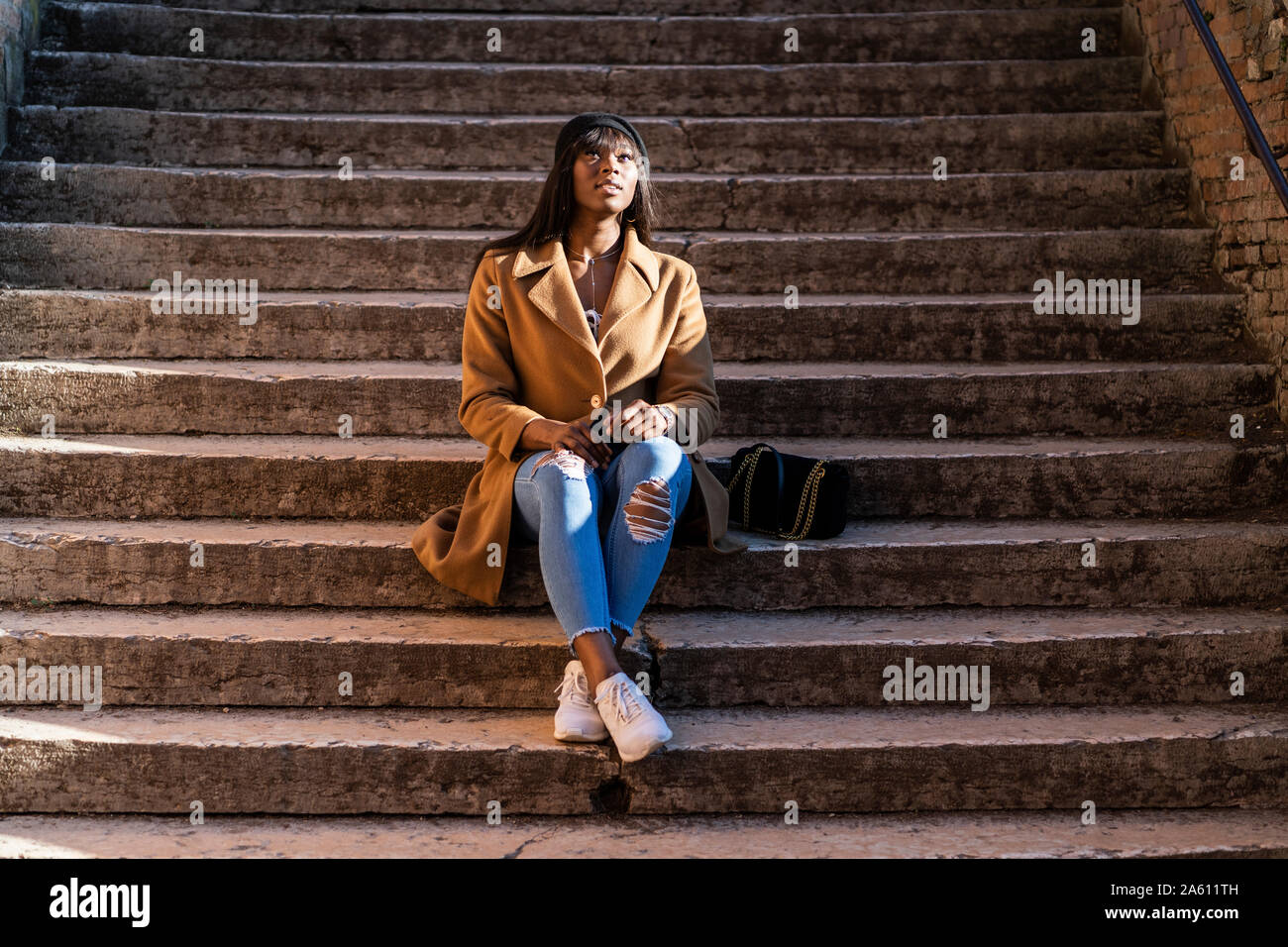 Woman sitting on stairs outdoors Banque D'Images