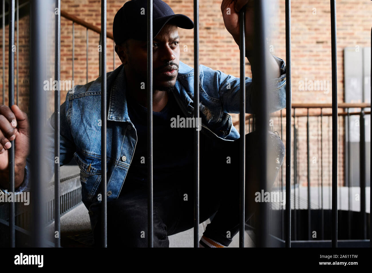 Portrait d'un homme accroupi dans les escaliers à la recherche à distance Banque D'Images