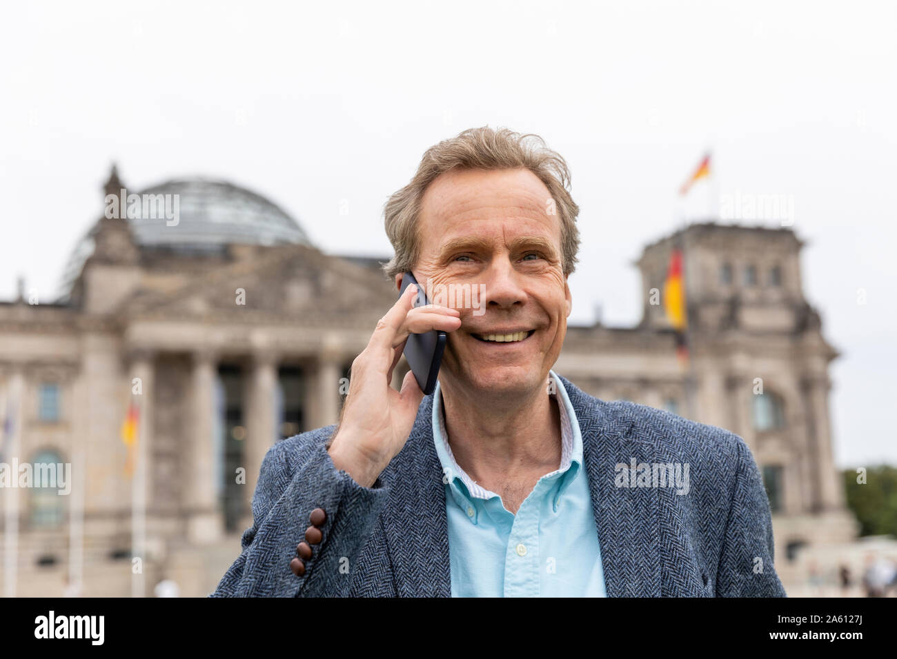 Portrait of smiling senior man sur le téléphone au Reichstag, Berlin, Allemagne Banque D'Images