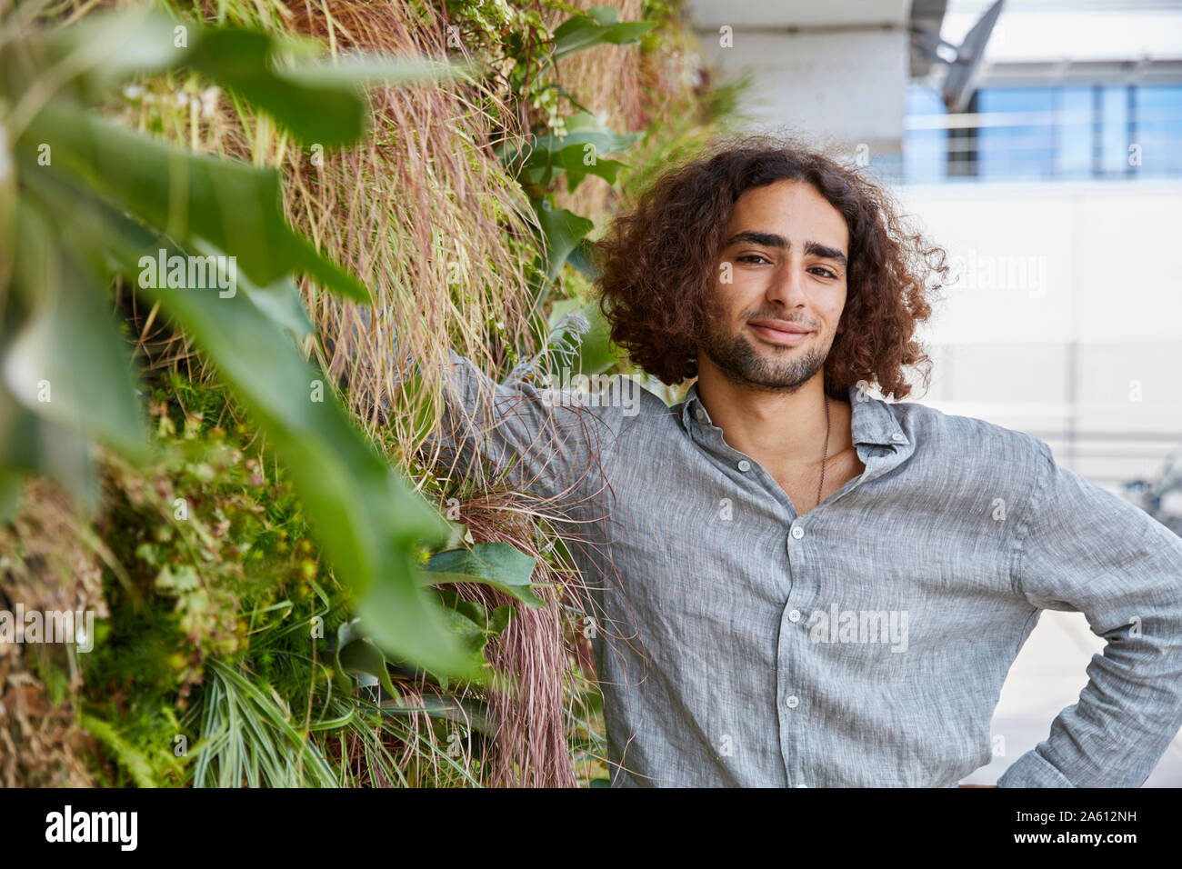 Portrait du jeune homme en face de mur végétal Banque D'Images