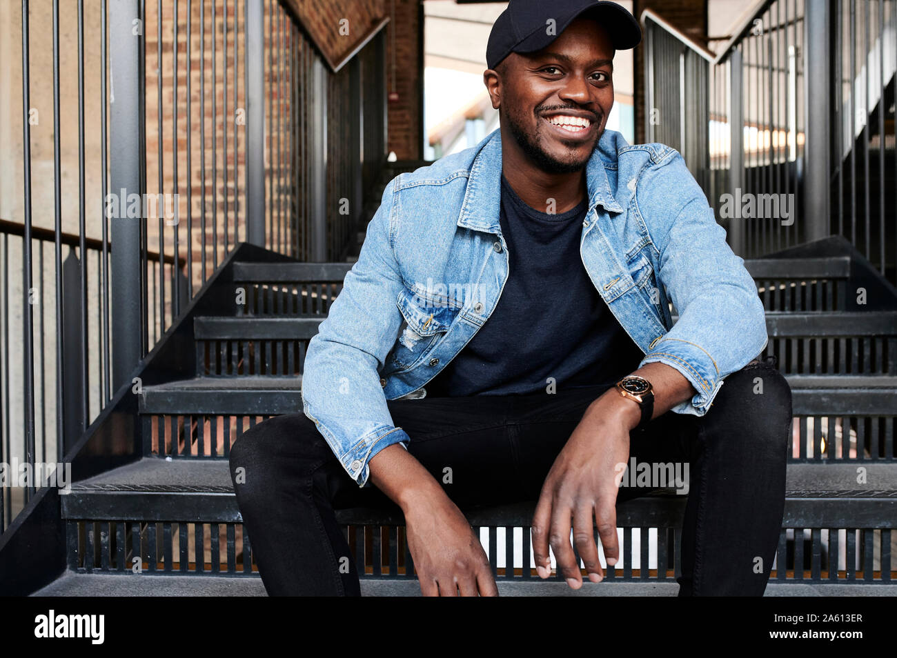 Portrait of laughing man sitting on stairs Banque D'Images