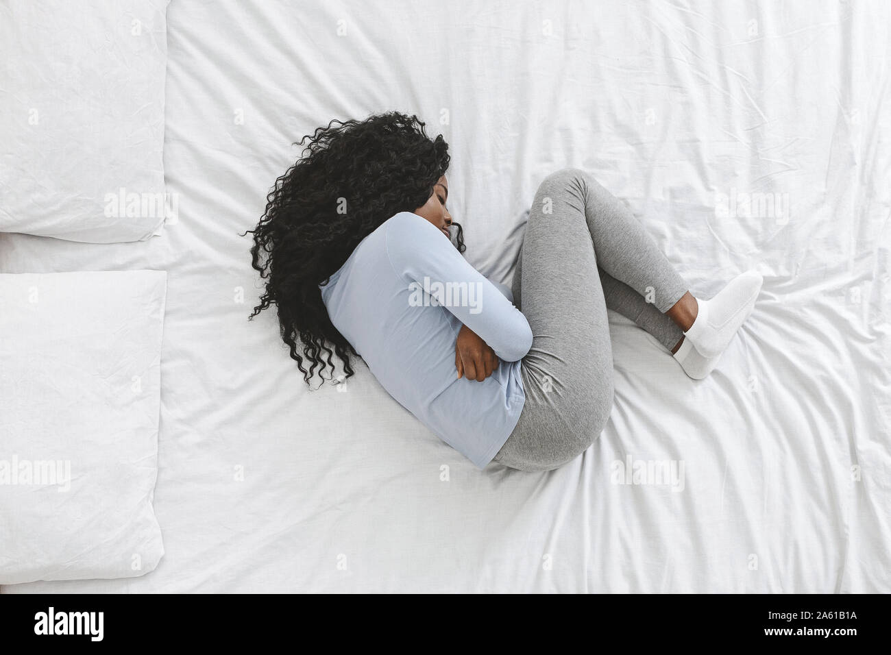 Vue de dessus de sick young woman Lying in Bed blanc Banque D'Images