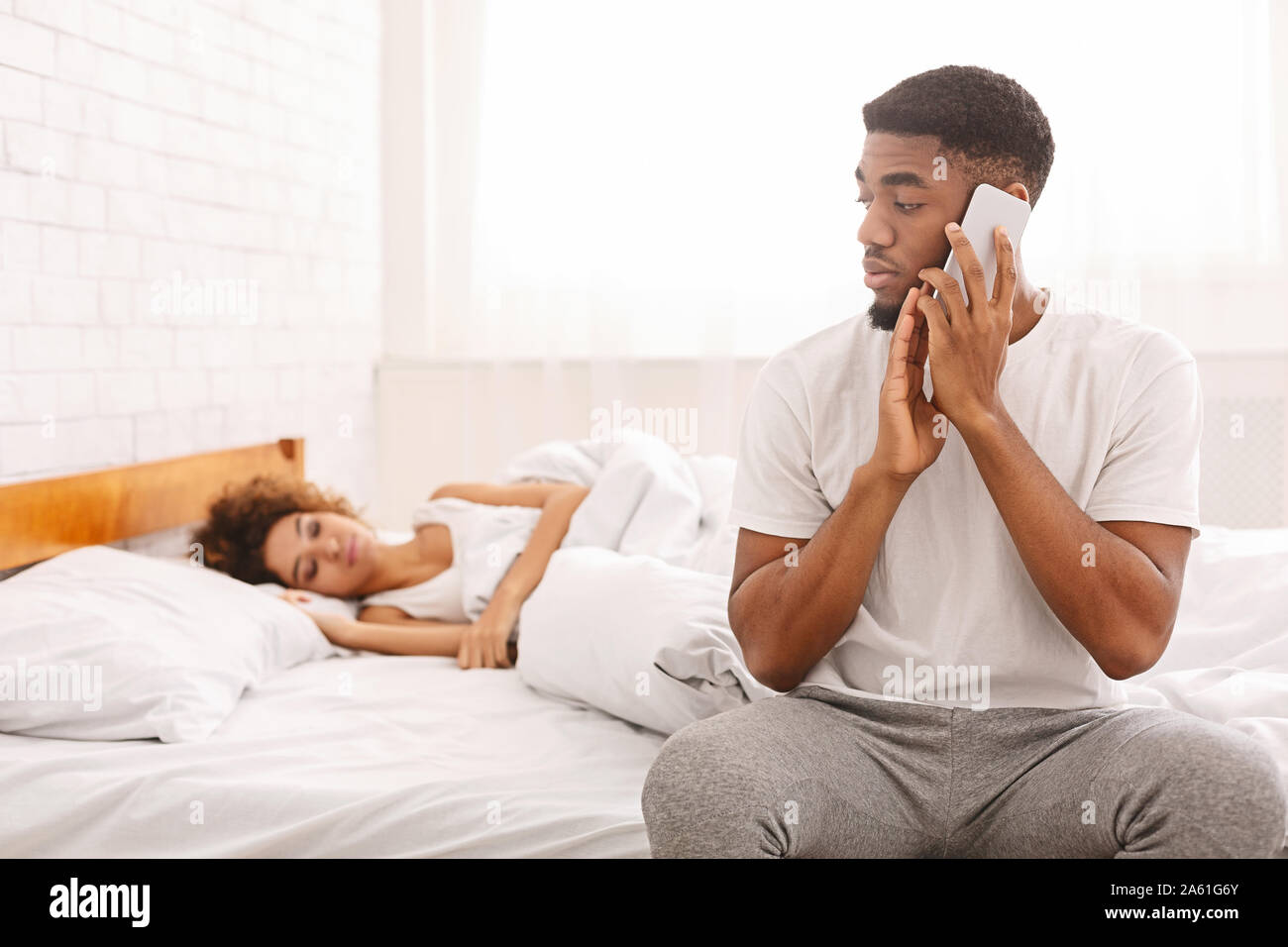 Homme africain parlant avec maîtresse à la maison, se cachant de sa femme Banque D'Images