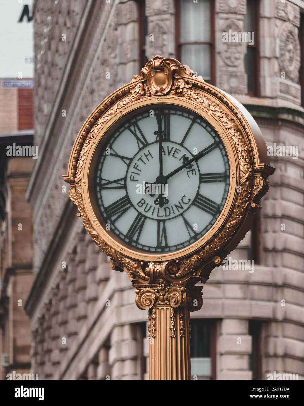 Horloge dorée sur la Cinquième Avenue, New York. Banque D'Images