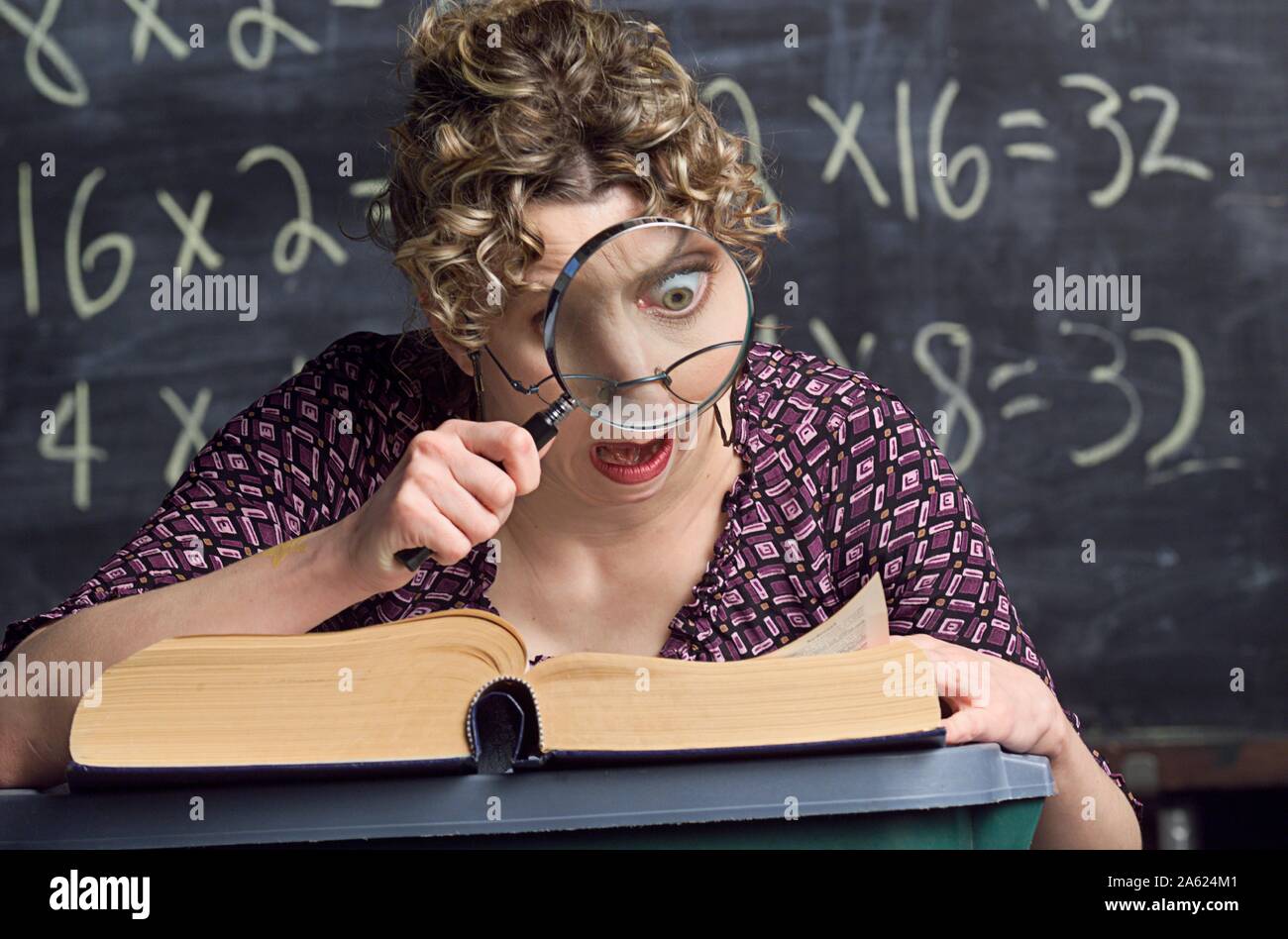 Snoopy enseignant découvre un nouveau mot dans le dictionnaire, à l'aide d'une grosse loupe Banque D'Images