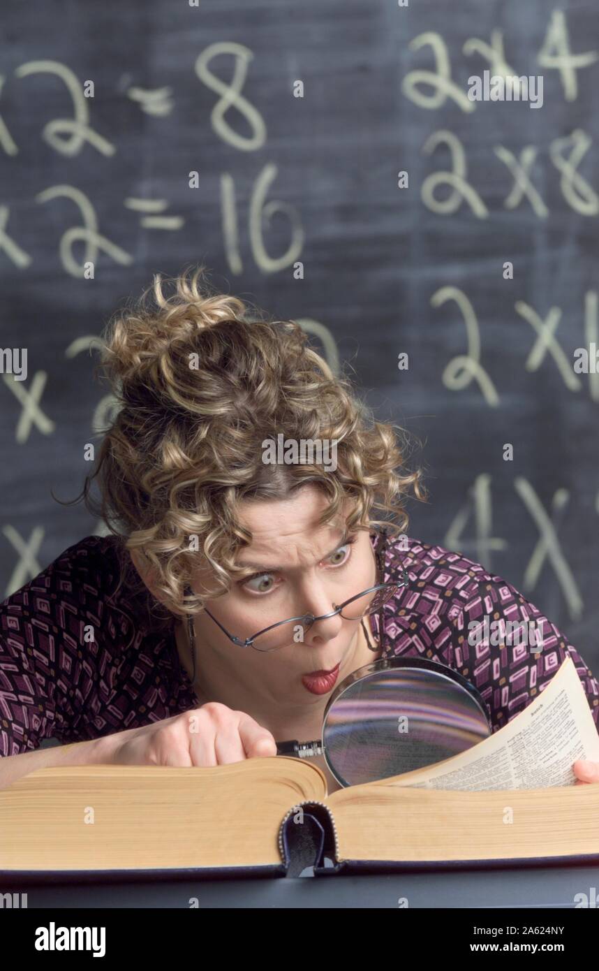 Photo humoristique d'un snoopy enseignant à l'aide d'une loupe pour regarder dans un dictionnaire Banque D'Images