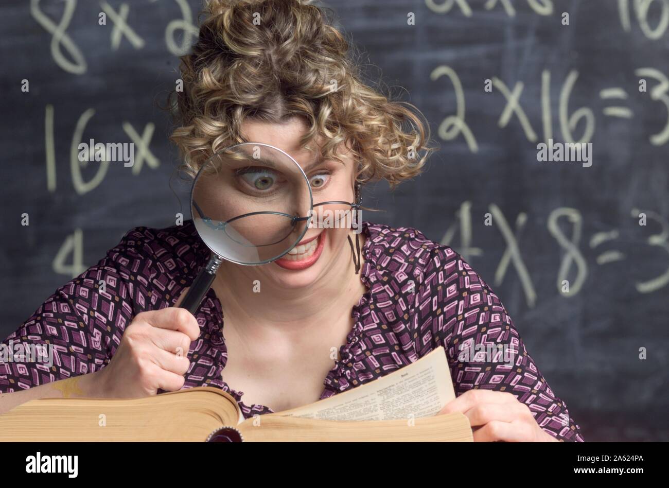 Photo humoristique d'un snoopy enseignant à l'aide d'une loupe pour regarder dans un dictionnaire Banque D'Images