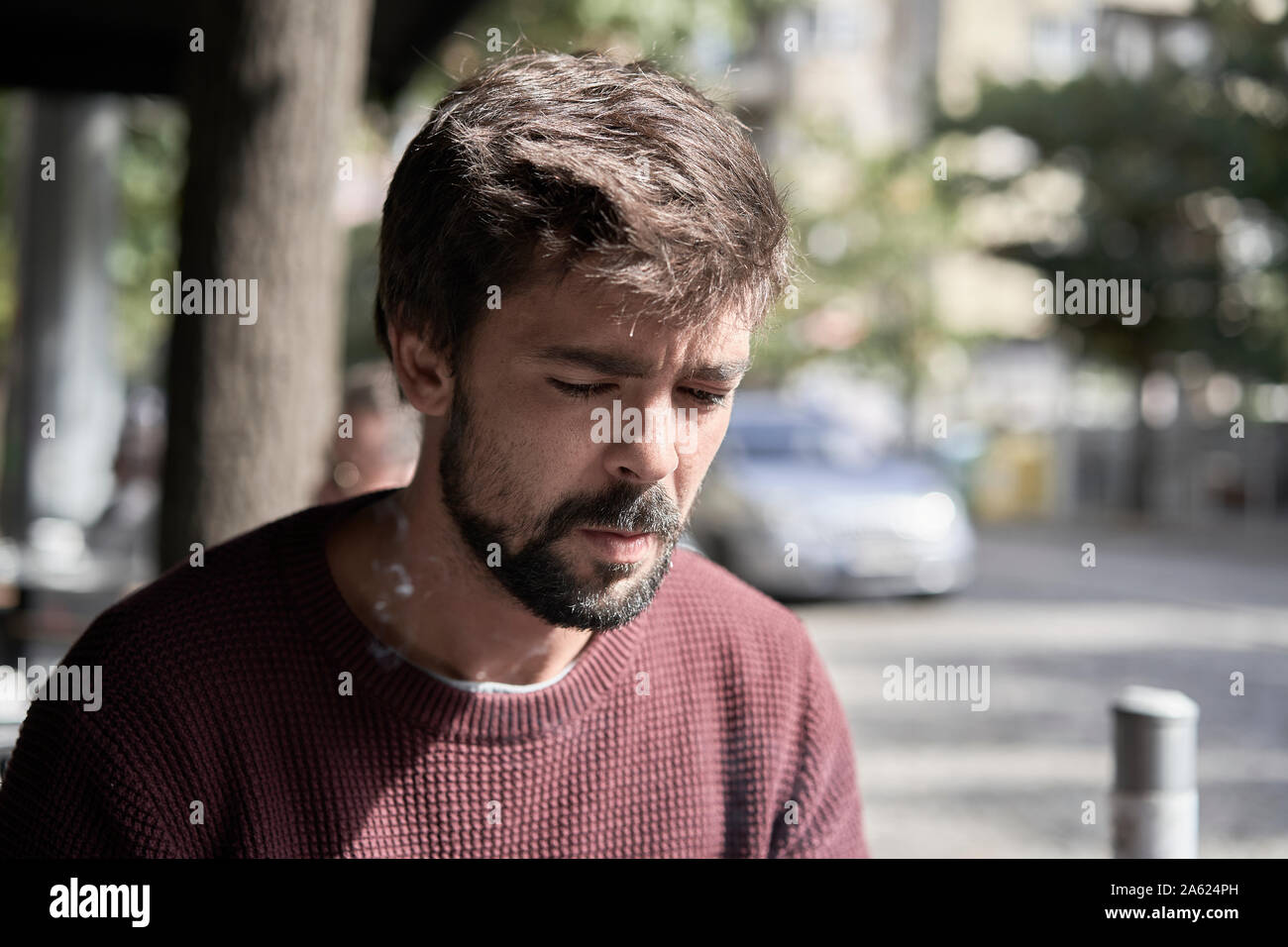 Séduisant jeune homme barbu en utilisant son smartphone dans le café Banque D'Images