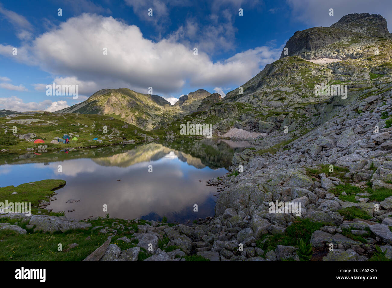 Un paysage extraordinaire dans la montagne bulgare, réflexion du ciel dans le lac et tentes autour du lac de montagne de Rila en Bulgarie. Banque D'Images