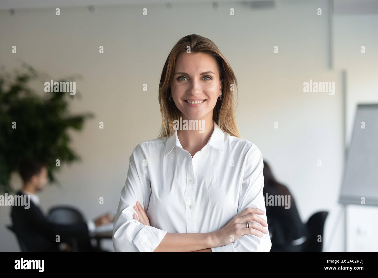 Female professional manager standing arms crossed looking at camera Banque D'Images