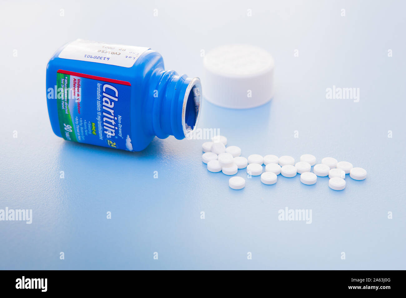 Claritin comprimés est un antihistaminique utilisé pour traiter les  symptômes d'allergies. Sur un fond bleu Photo Stock - Alamy