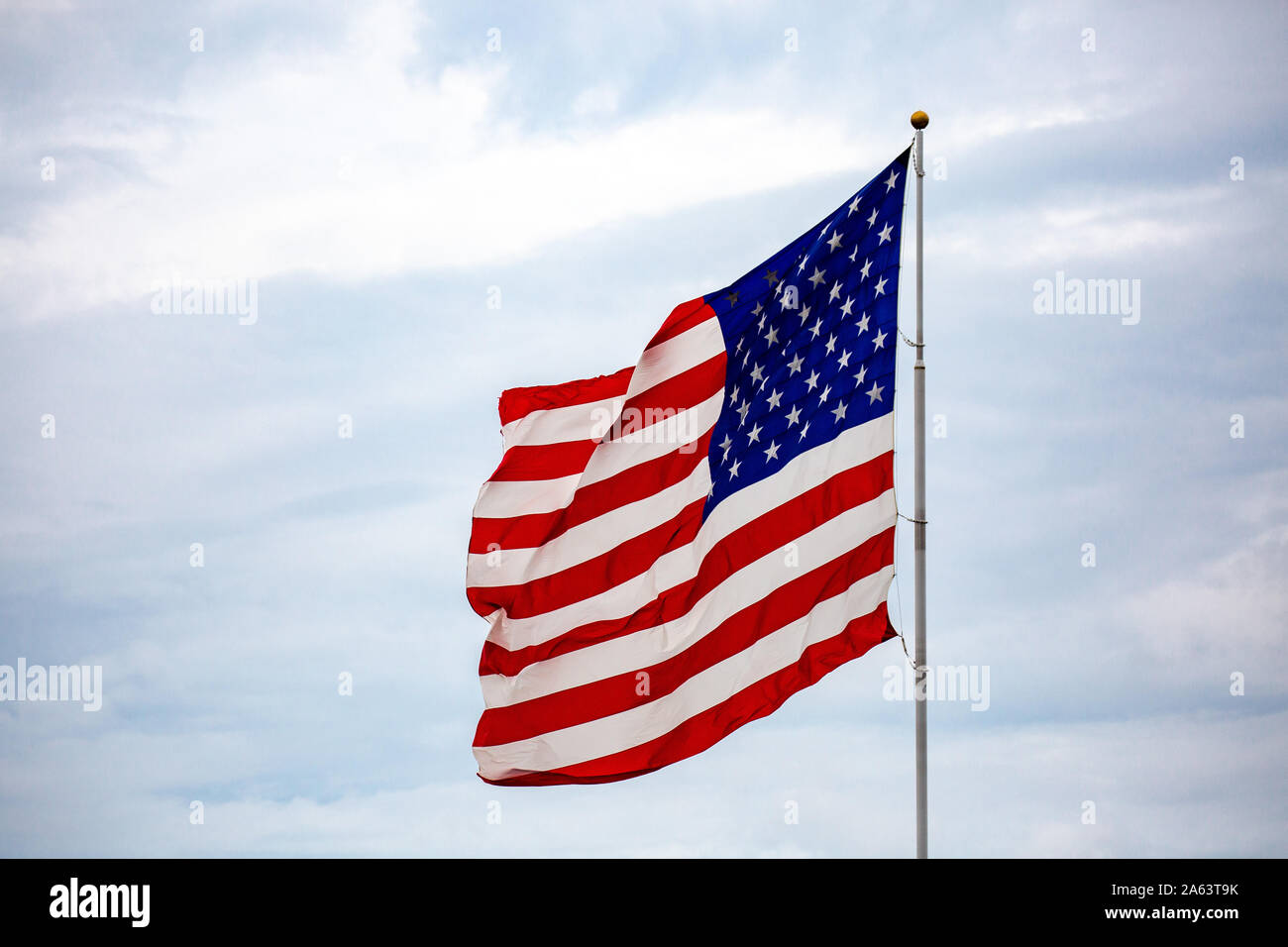 Brandir le drapeau américain dans le vent avec des nuages en arrière-plan Banque D'Images