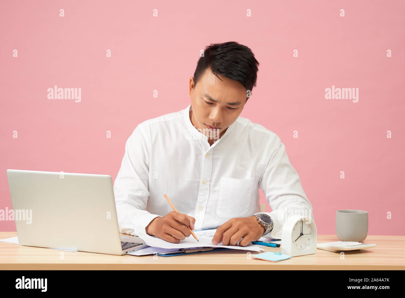 Young attractive asian businessman using laptop sitting on desk in office Banque D'Images