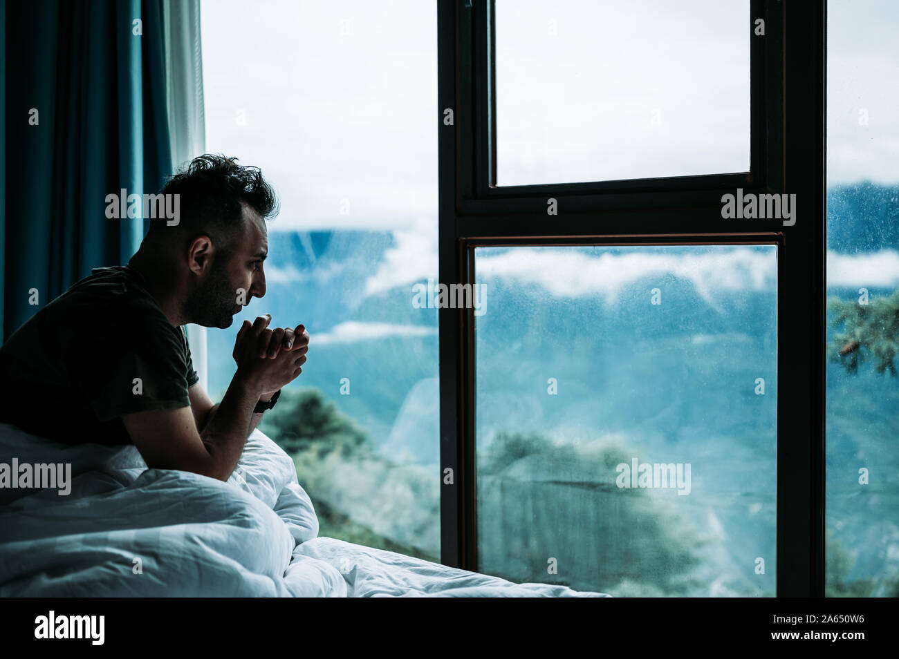 Voyage arménien caucasien se réveiller dans un cottage de montagne avec une vue parfaite sur le lever du soleil sur les montagnes. Brouillard et fraîcheur le matin. L'homme boit du thé. Banque D'Images