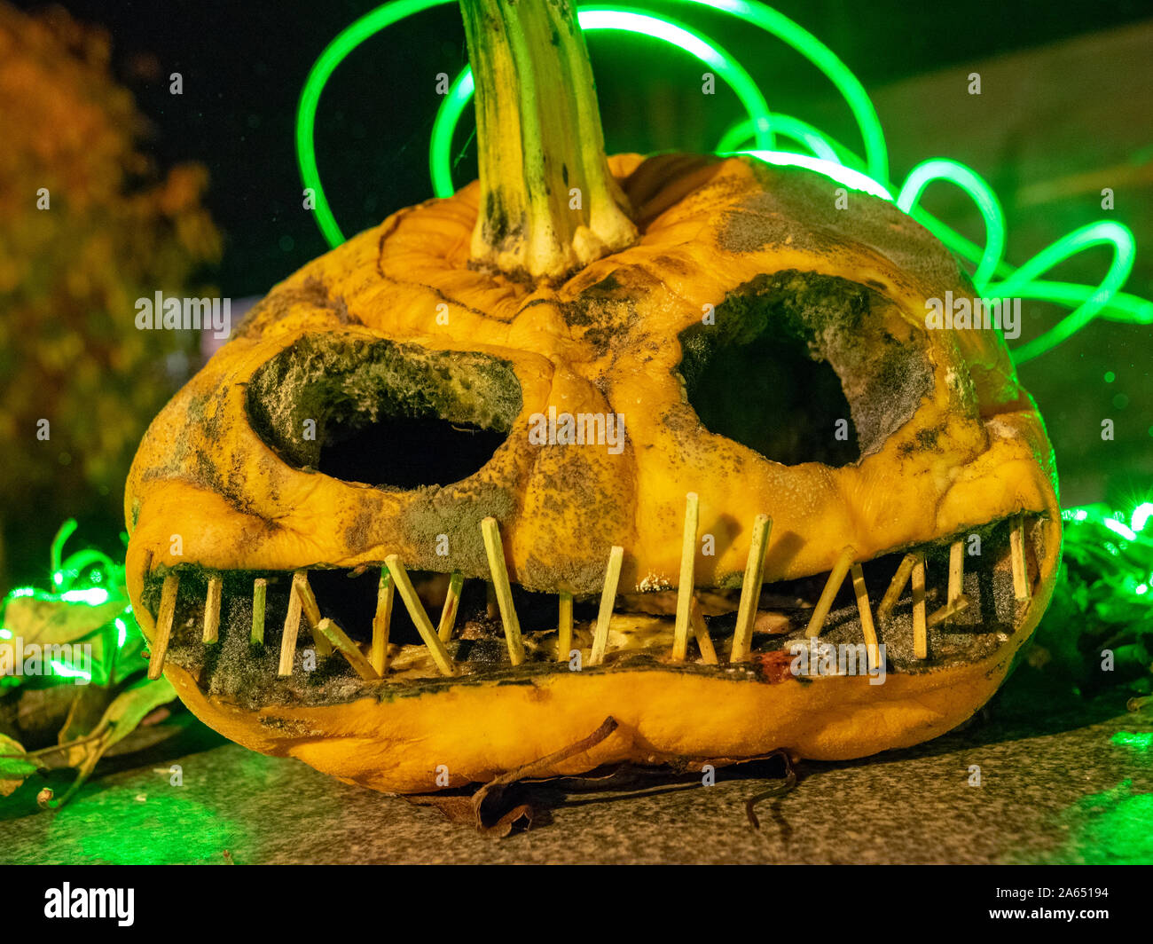 Citrouille sculptée terrible et dessins de lumière colorée à l'arrière-plan, adapté pour l'Halloween Banque D'Images