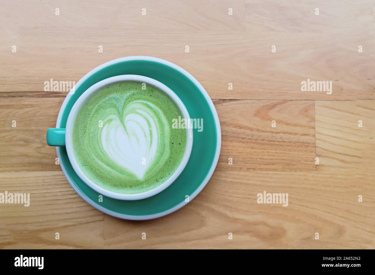 Une tasse de thé matcha latte avec le dessin sur la table en bois, Banque D'Images