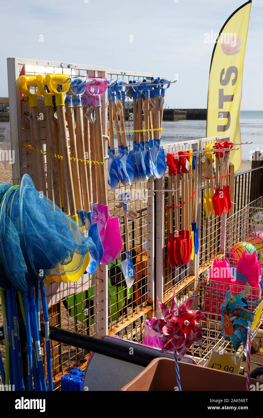 Jouets de plage colorés, seaux et pique, filets de pêche, balles de plage Windrills et beignets à vendre à un Stall dans Scarborough Yorkshire Angleterre Royaume-Uni Banque D'Images