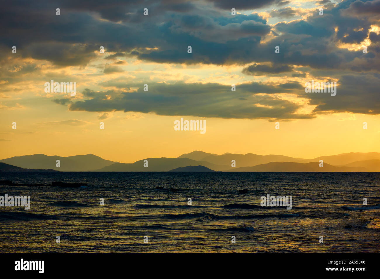 Coucher du soleil sur la mer et terre avec des montagnes à l'horizon - Coucher de saescape, paysage Banque D'Images