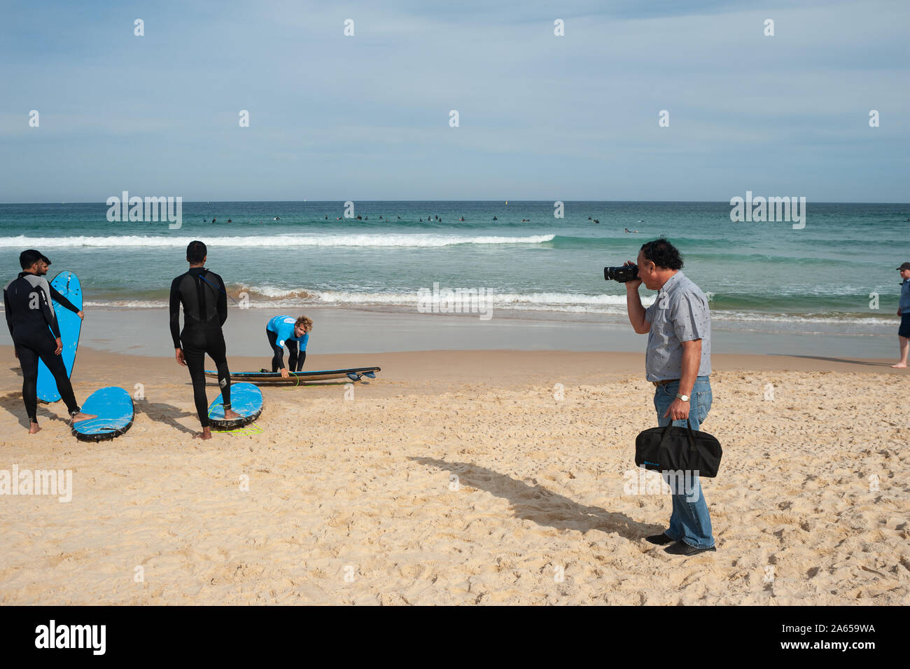 27.09.2019, Sydney, Nouvelle-Galles du Sud, Australie - un homme portant des combinaisons de surfeurs des films sur la plage de Bondi. Banque D'Images