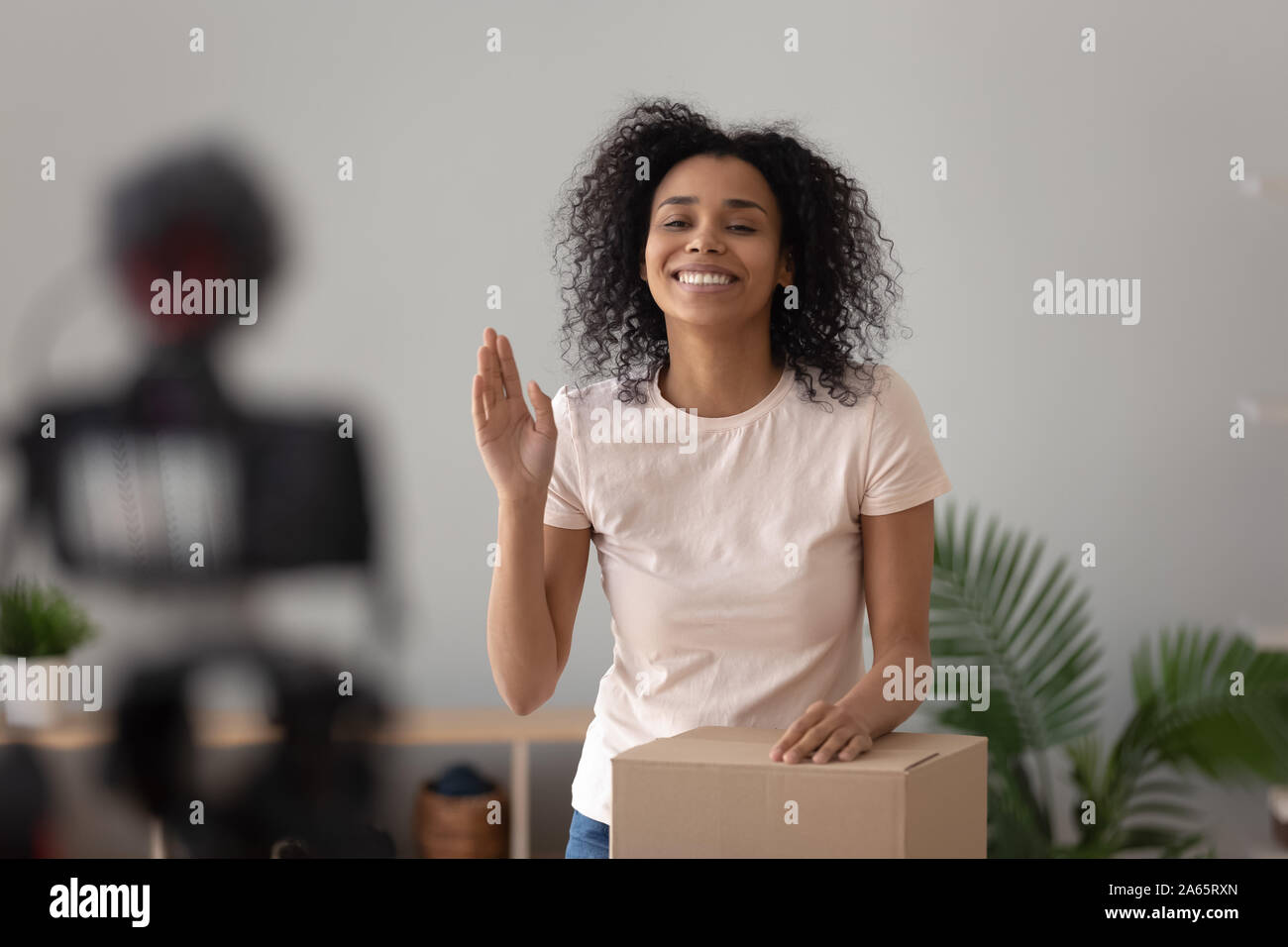 Smiling girl biracial tourner une vidéo déballage blog Banque D'Images