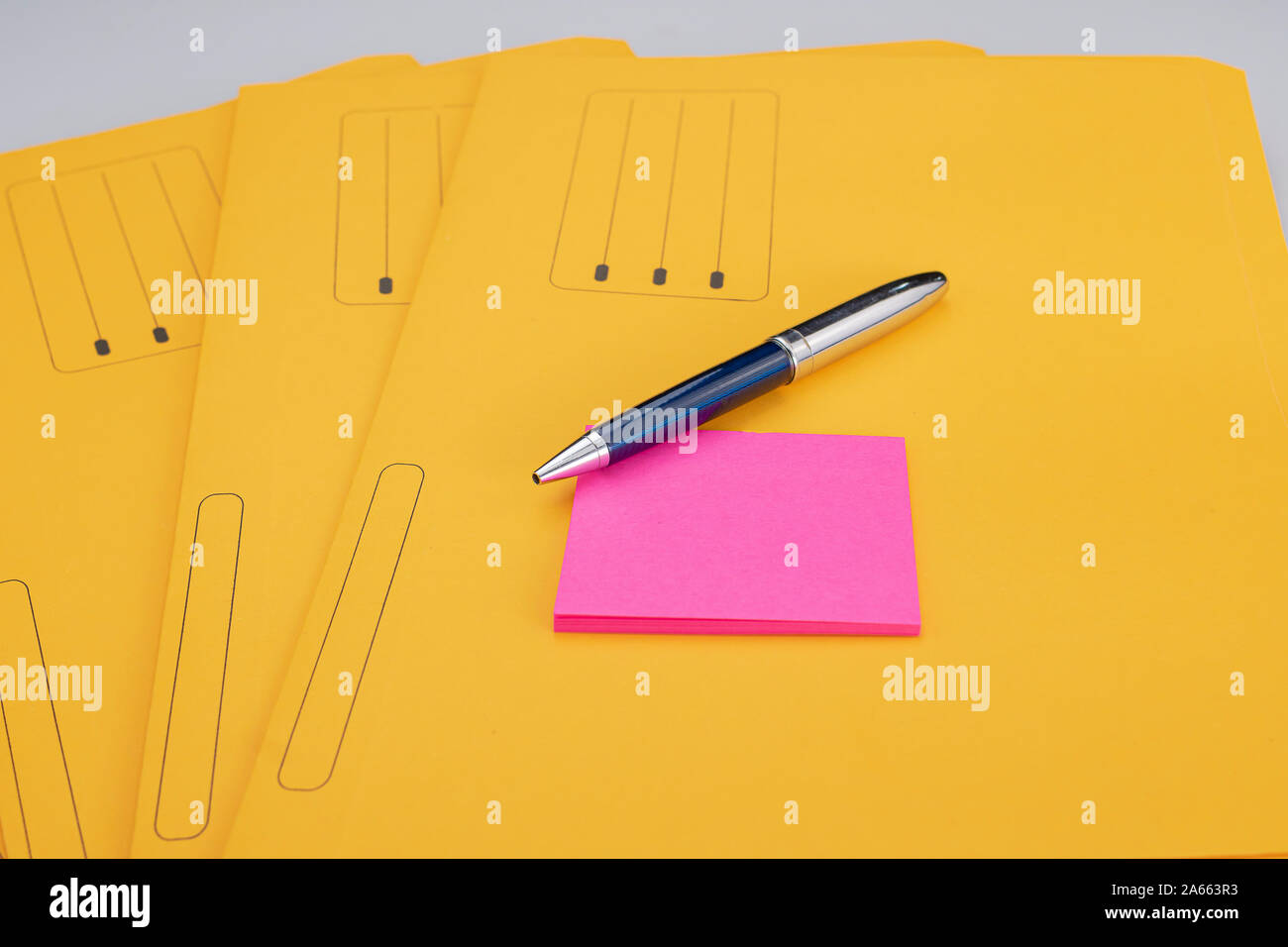 Fournitures de bureau moderne composé d'un stylo et bloc-notes jaune fuchsia sur sous-dossiers Banque D'Images