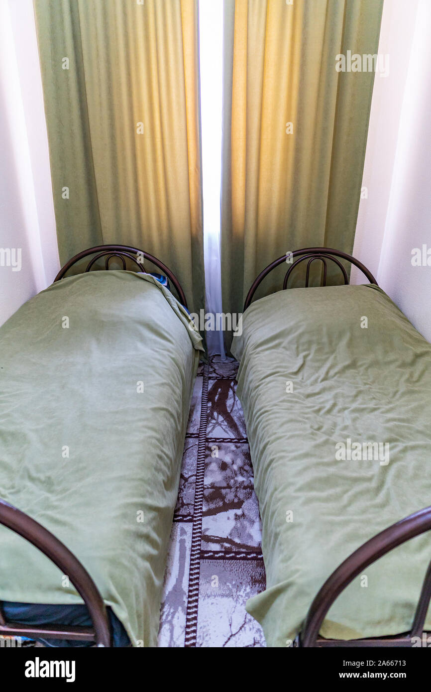 Simple auberge Chambre lits jumeaux avec draps et rideaux de couleur Orange  Box modeste Photo Stock - Alamy