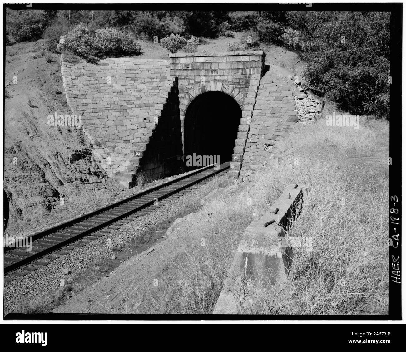Portail ouest du Tunnel 23, vue vers le nord, 135mm. Fondation en béton à droite au premier plan était de 'pneus', une simple à poteaux et poutres qui s'étendait sur toute la trame de fond avec les longueurs de corde suspendue à la poutre. À l'époque où les serre-freins étaient tenus d'être sur, et marcher le long, le dessus des wagons de marchandises pour serrer les freins, le témoin 'cordes' ne frappe l'imprudent pour avertir du tunnel de l'avant, leur permettant d'être à plat et ne pas être frappé par le portail du tunnel. - Chemin de fer transcontinental du Pacifique Central, Tunnel no 23, point milliaire 132,69, Applegate, placer County, CA ; Banque D'Images