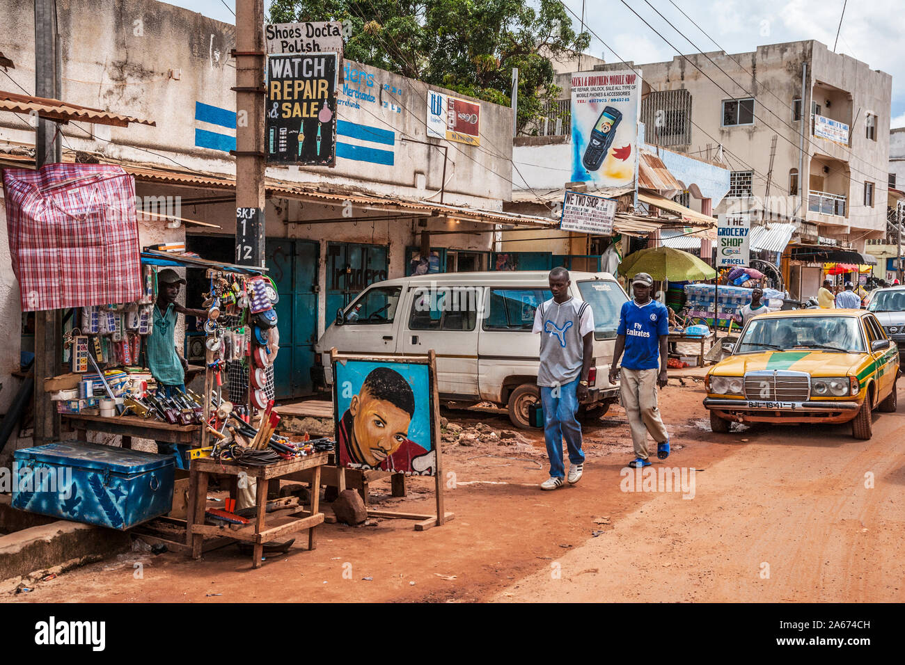 Une longue scène de rue à Serrekunda en Gambie, Afrique de l'Ouest. Banque D'Images